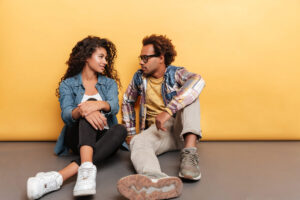 Two people talking calmly at a table with mugs, suggesting a relationship check-in